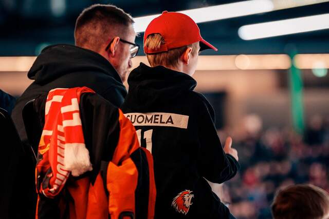 Un père et son fils regardent le match depuis le Family Corner